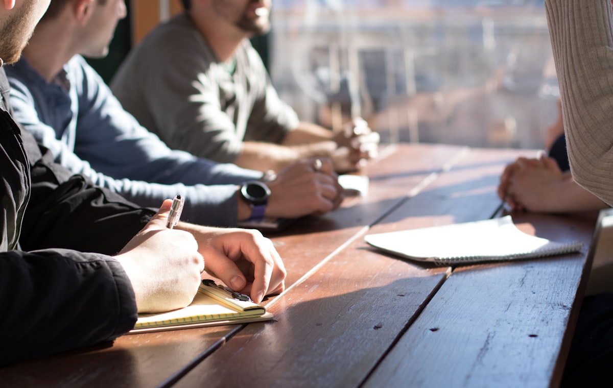 Personas revisando información y tomando decisiones alrededor de una mesa